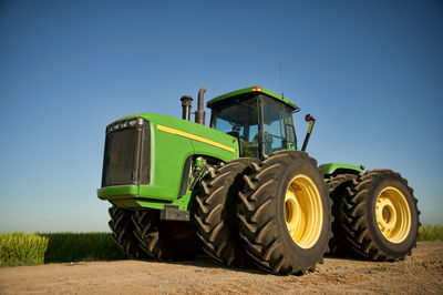 Low angle view of tractor against blue sky