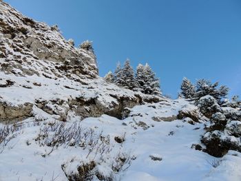 Low angle view of snowcapped mountain against blue sky