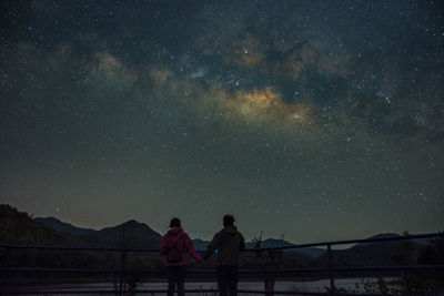 People on mountain against sky at night