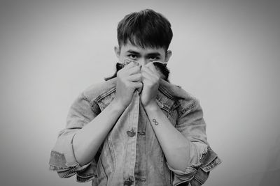 Portrait of boy standing against white background