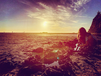 Man looking at sea against sky during sunset