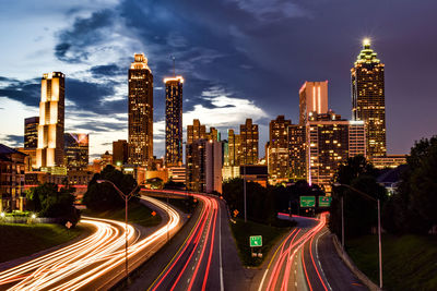 High angle view of light trails on road amidst buildings in city