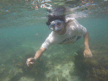 Young man swimming under sea