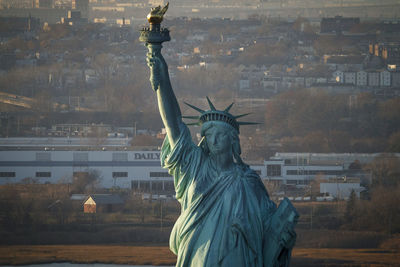 Sunset on the statue of liberty in new york harbor, new york city.