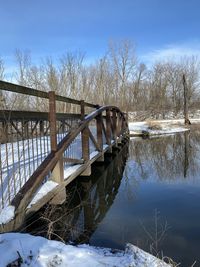 Bridge over river against sky during winter
