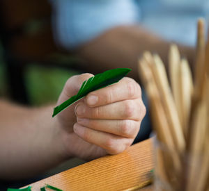 Close-up of person hands cutting paper with scissors on table