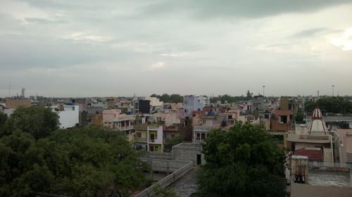 High angle shot of townscape against cloudy sky