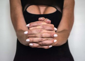 Midsection of woman with hands clasped