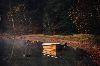 Boat moored in lake against trees