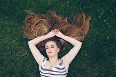 High angle view of woman relaxing on grassy field