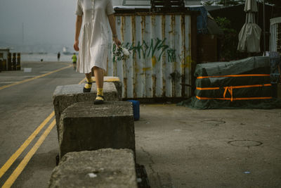 Low section of woman walking on concrete stones on street