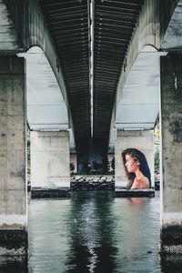 Woman standing by bridge