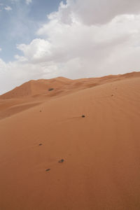 Scenic view of desert against cloudy sky