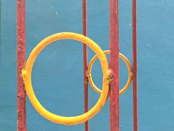 Close-up of yellow metal against blue wall