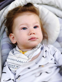 Close-up of cute baby relaxing on bed at home