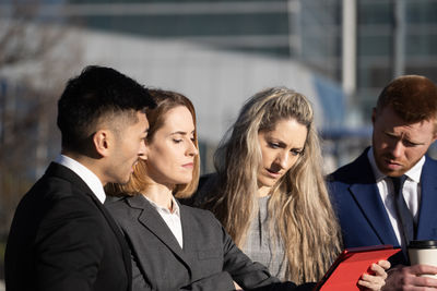 Side view of business people focused and serious looking at important information
