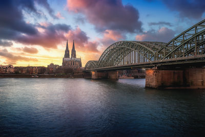 Bridge over river against cloudy sky