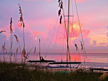 Boats in sea at sunset