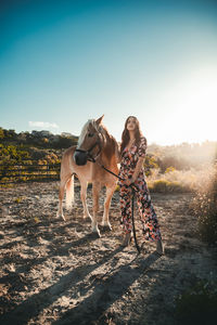 The girl relaxes with the white horse in the nature park