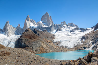 Scenic view of snowcapped mountains against clear blue sky