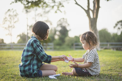 Side view of mother and daughter at park