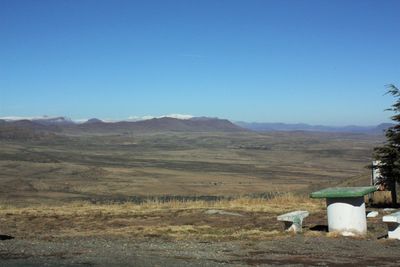 Seats on landscape against sky