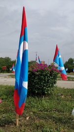 Multi colored flags on field against sky