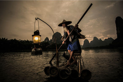 Boats in river at sunset