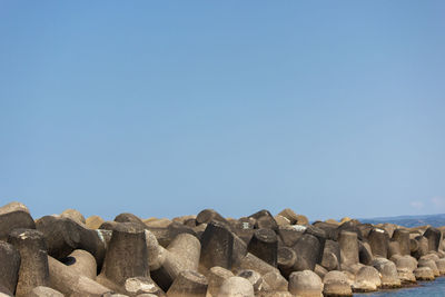 Stack of rocks against clear blue sky