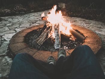 Low section of man wearing high angle view of bonfire