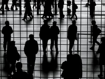 Silhouette people standing on tiled floor