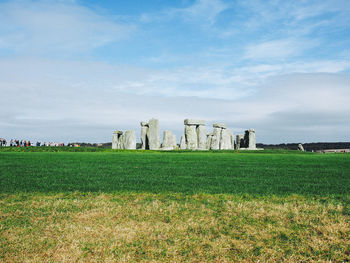 Scenic view of field against cloudy sky