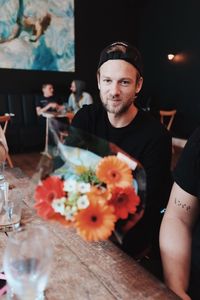 Portrait of woman with flower bouquet on table