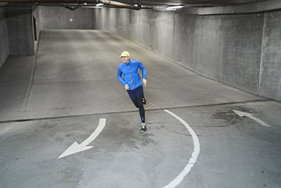 Mature man running in parking garage of residential building