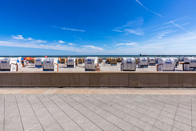 View of footpath by city against blue sky