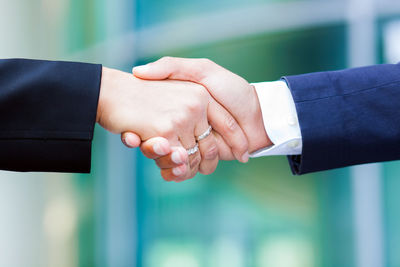 Midsection of business colleagues shaking hands outdoors