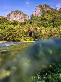 Surface level of water by rocks against sky