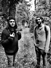 Portrait of young couple standing against trees