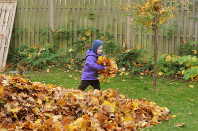 Woman standing with flowers in autumn leaves