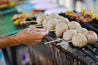 Person preparing food on barbecue grill