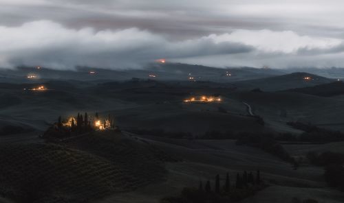 Aerial view of illuminated landscape against sky at night