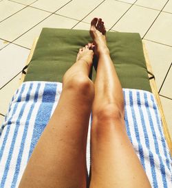 Low section of woman relaxing on swimming pool