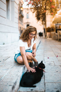 Full length of woman sitting outdoors