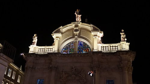 Low angle view of illuminated building against sky at night