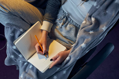 Student learning at home. young woman making notes, reading and learning from notepad