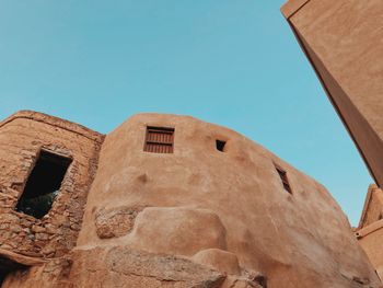 Low angle view of old building against clear blue sky