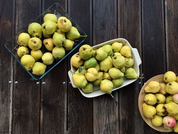 High angle view of pears in containers on wooden table