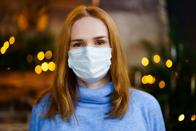 Portrait of beautiful woman wearing mask standing outdoors