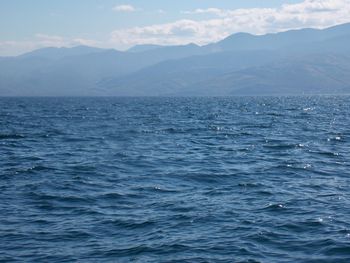 Scenic view of sea and mountains against sky