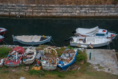 New boats moored next to destroyed old boats, corfu, greece